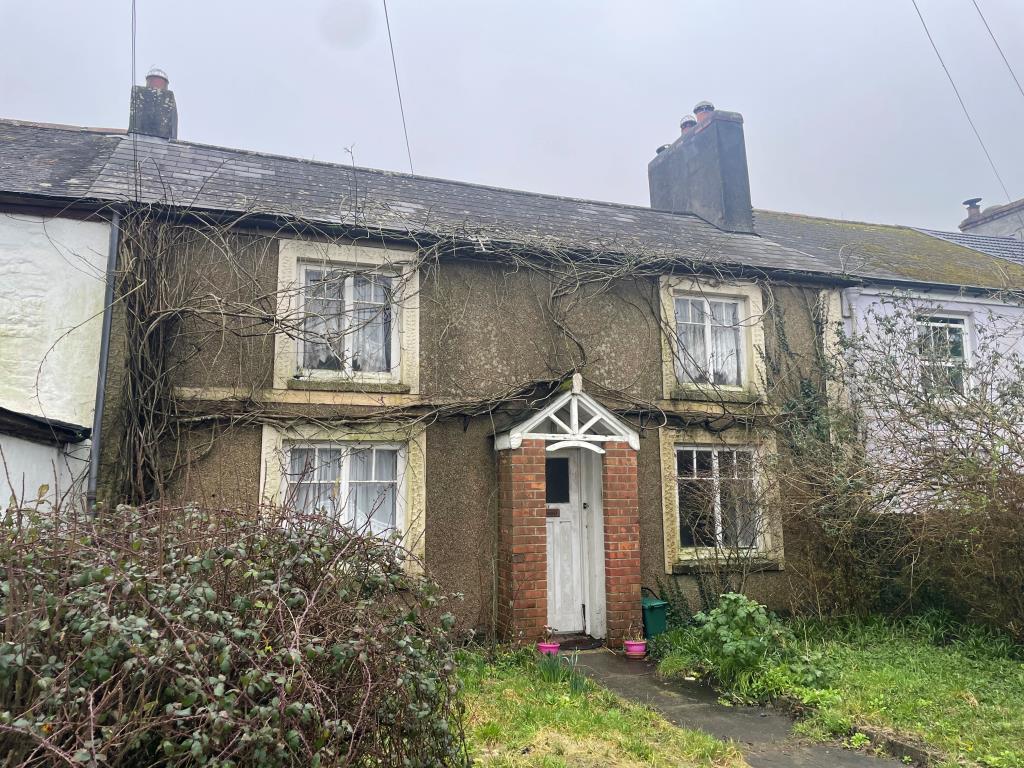 Lot: 127 - TERRACE HOUSE WITH ADDITIONAL ONE-BEDROOM DWELLING, GARAGE, OUTBUILDING AND LARGE GARDEN SPACE - Front of property with garden space in foreground